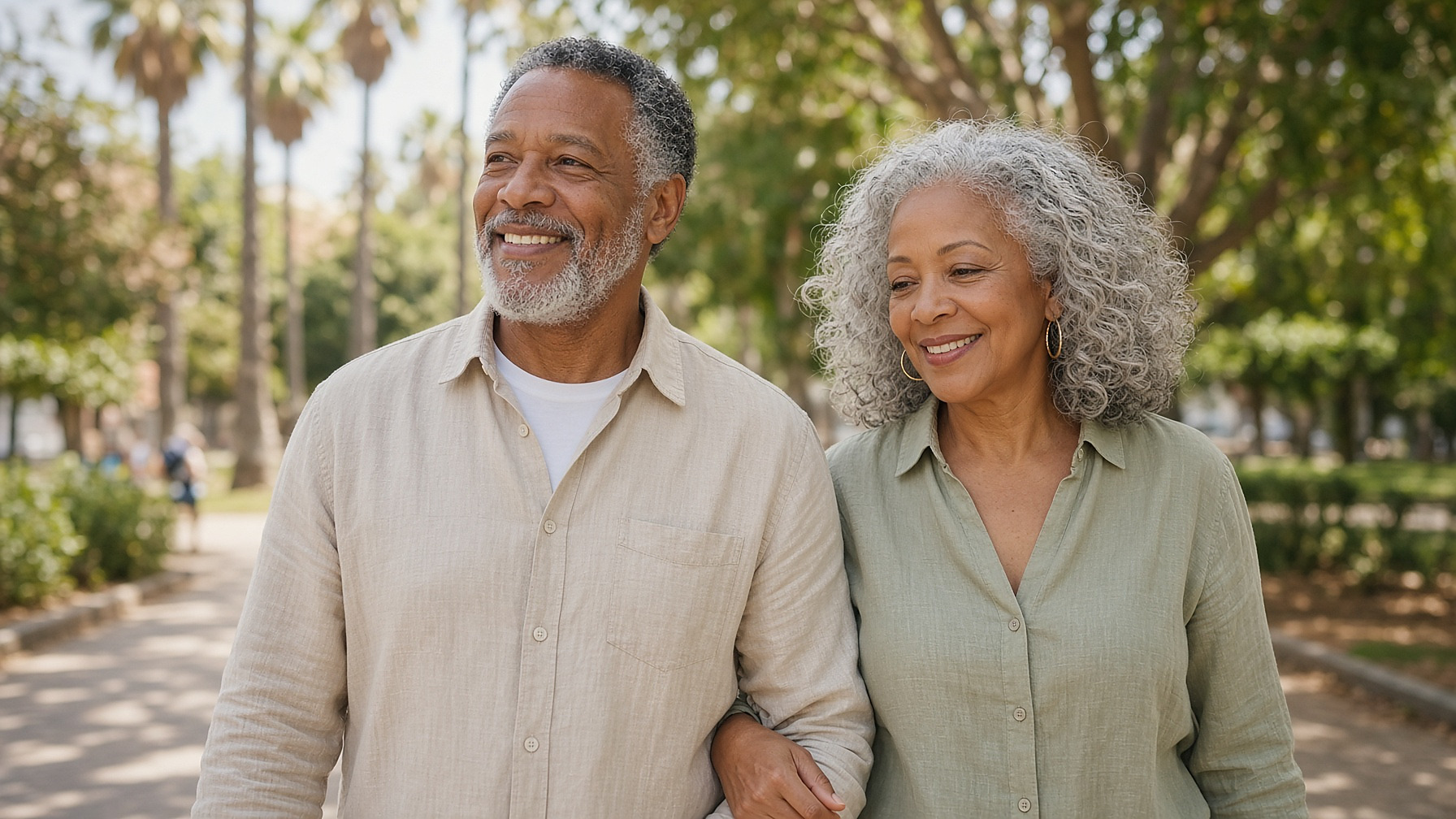 An African American mixed-race senior couple walking together on a sunny park path